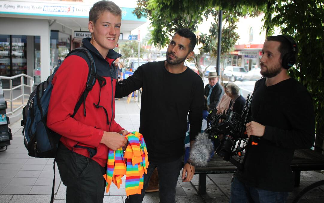 COLOURFUL EQUALITY CAMPAIGN: Jim Campbell hands out rainbow socks on the main street of Bega with SBS journalists Patrick Abboud and Daniel Gwynn in tow.