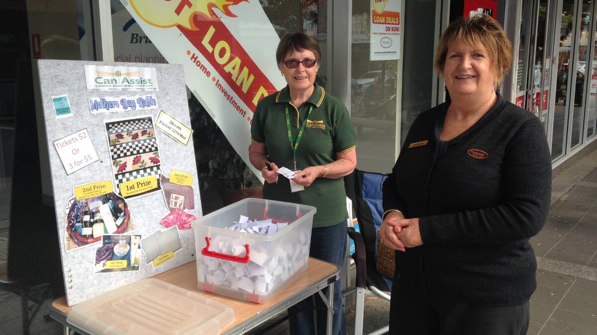 LUCKY DIP: Pam Tetley, from Bega Valley Can Assist, and Marlene Taylor, from Horizon, draw winners in the Mother's Day raffle. Community notices, page 14.
