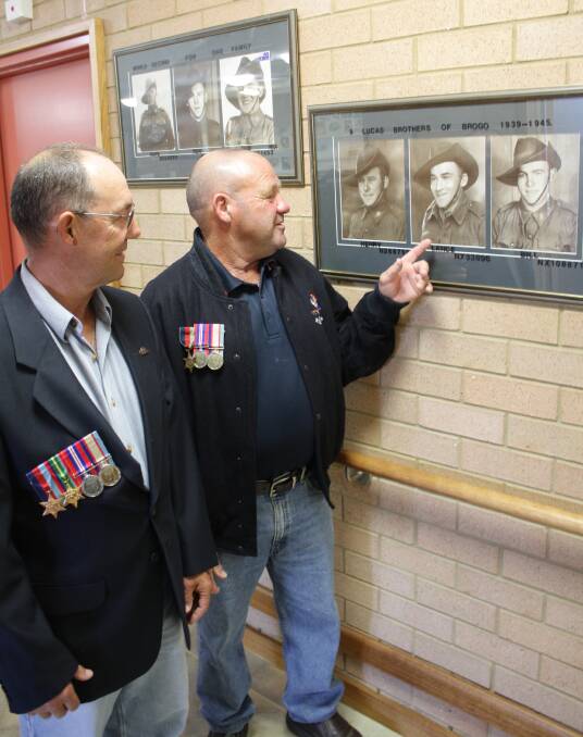 In this BDN photo from 2010, Geoffrey (Hedley) and Henry Lucas, proudly wearing their father’s medals, admire a  photo of their dad, Lance.