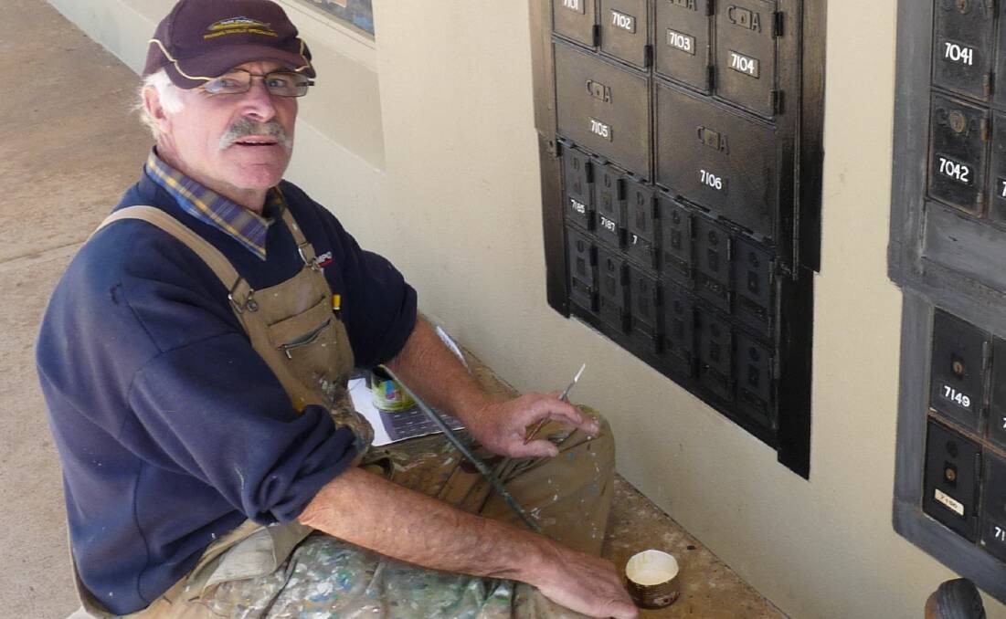 VALUED SKILL: Rather than use plastic stickers, signwriter John Davidson paints numbers on the Tathra Post Office's PO boxes.