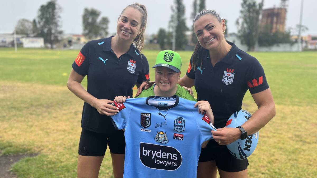 Ada smiles holding a signed Blues jersey alongside Kezie Apps and Millie Elliott. Picture by James Parker