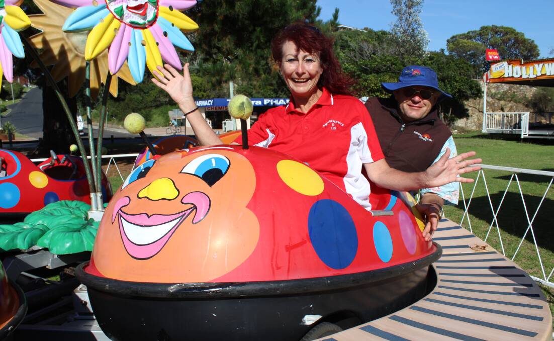 FUN TIMES: Gina Newman and Martin Byrne from Amusements R Us take a spin on the lady beetle ride after setting up at Tathra.