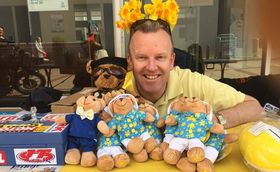 CANCER COUNCIL FUNDRAISER: Editor Ben Smyth lends a hand at the Daffodil Day merchandise stall in Ayres Walkway, Bega, on Friday.