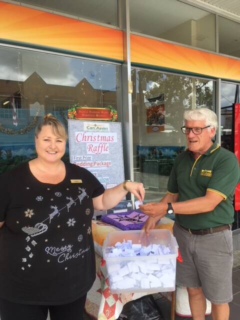 Joanne Ward and Peter van Bracht draw the Bega Valley Can Assist Christmas raffle. The winner was Mary Scollen and second was Lorraine Colless.