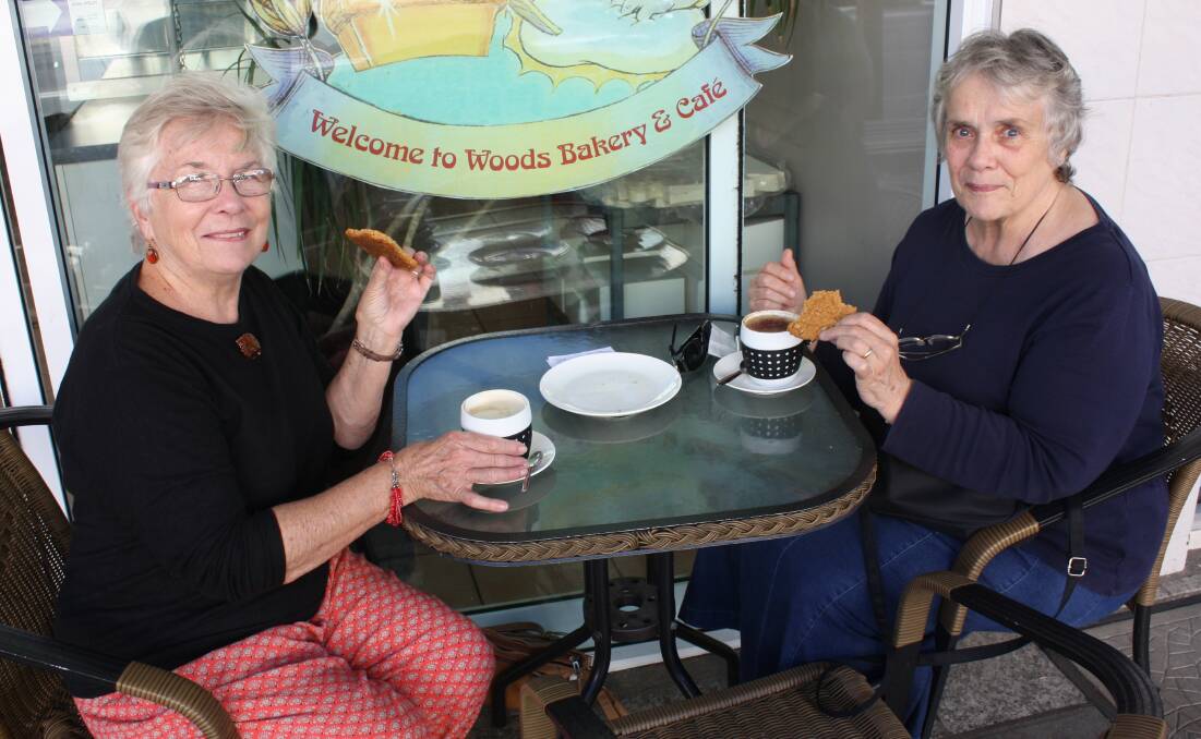 CUPPA: Sisters Pat and Bridget O'Hanlon enjoy Anzac cookies at Woods Bakery after the Bega Anzac Day march and service on Monday.
