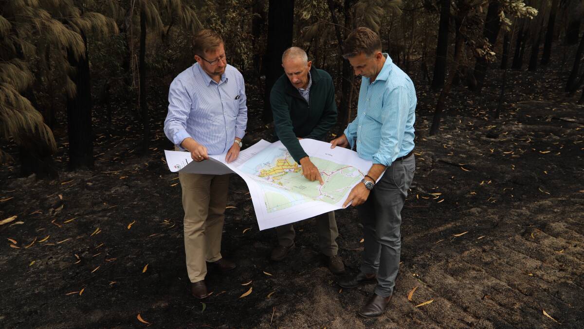 Emergency Services Minister Troy Grant visits Tathra to discuss the recovery process with coordinator Euan Ferguson and Bega MP Andrew Constance.