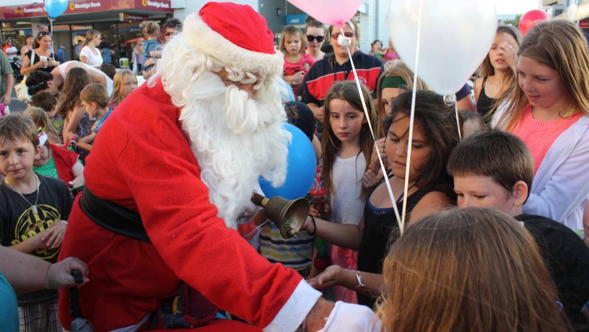 Santa and numerous young fans at the 2015 Bega Christmas Carnivale.