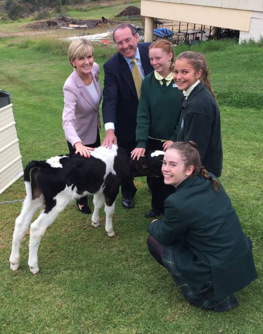 Minister for Foreign Affairs Julie Bishop and Eden-Monaro MP Peter Hendy pat a calf at the Sapphire Coast Anglican College with student leaders Natasha Oesch, Libby Hurley and Maddie Gordon.
