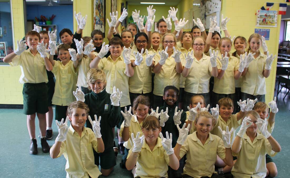 The SCAC junior choir wear white gloves that will make their hands glow during their Auslan carols performance. 