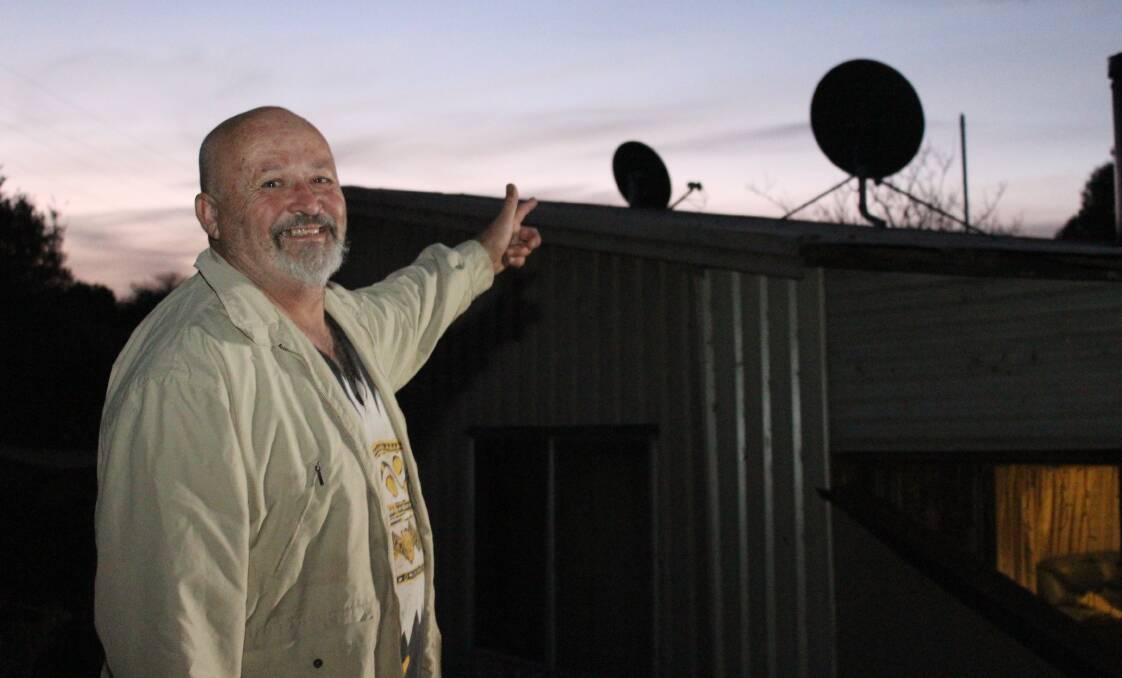Rod Niemeier points out the inactive NBN satellite dish on his roof. He switched back to ADSL after two weeks because of poor service. Photo: Alana Beitz