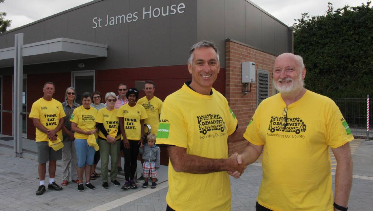 HANDOVER: Reverend Michael Palmer with Peter Buggy and volunteers, as OzHarvest moves into its new home.
