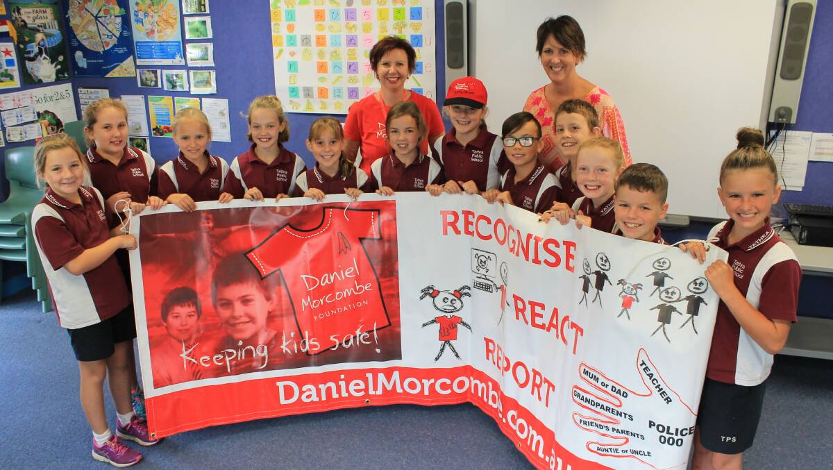 GOING RED: Tathra Public School Year 5 pupils show off a Daniel Morcombe Foundation sign with Melissa Pouliot and Lisa Freedman.