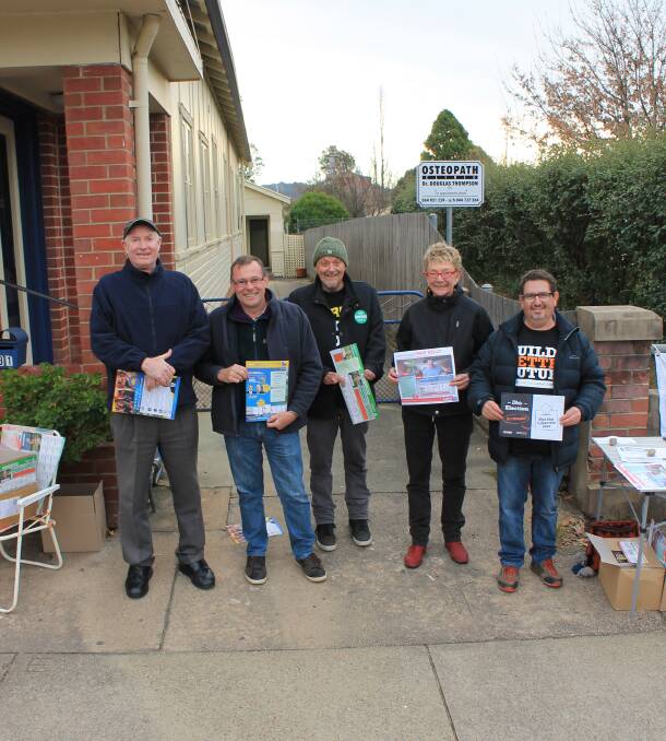 EXCITEMENT BUILDS: Dave Richard-Preston, Dennis Mortimer, Jamie Shaw, Jenny Van Gorder and Matt McCann hand out cards outside the CWA Hall in Bega on Monday.