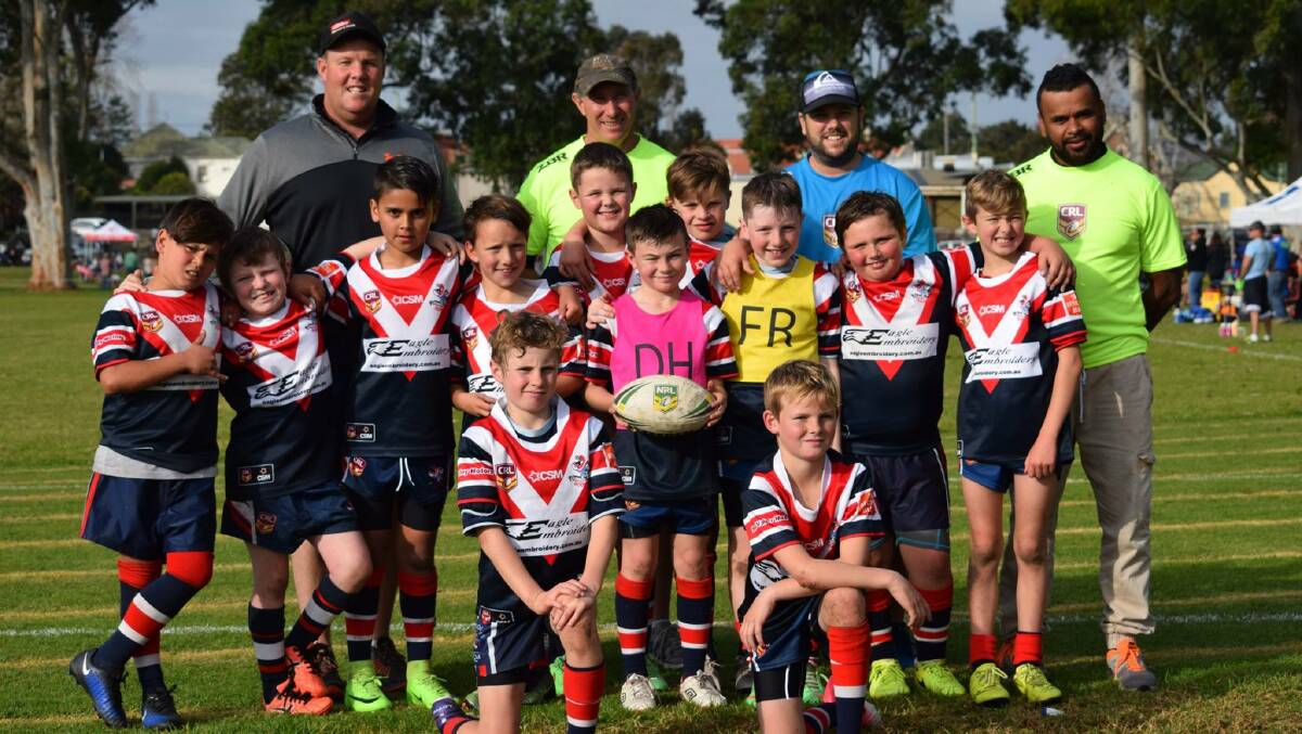 Champion Roosters: Bega's carnival-winning under 10s celebrate with their coach and support after the final. Picture: Wendy Deighton. 