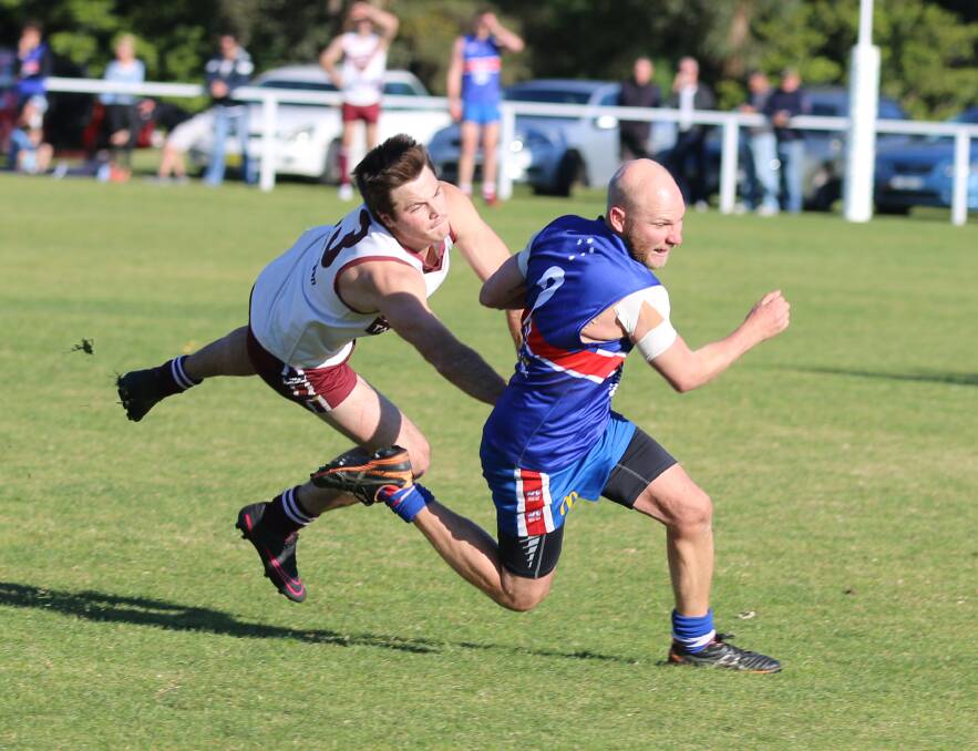 Tathra's Scott Hay clings to Merimbula veteran Wayne McKenzie during the grand final last year with both clubs booked in for Saturday's Lightning Cup draw. 