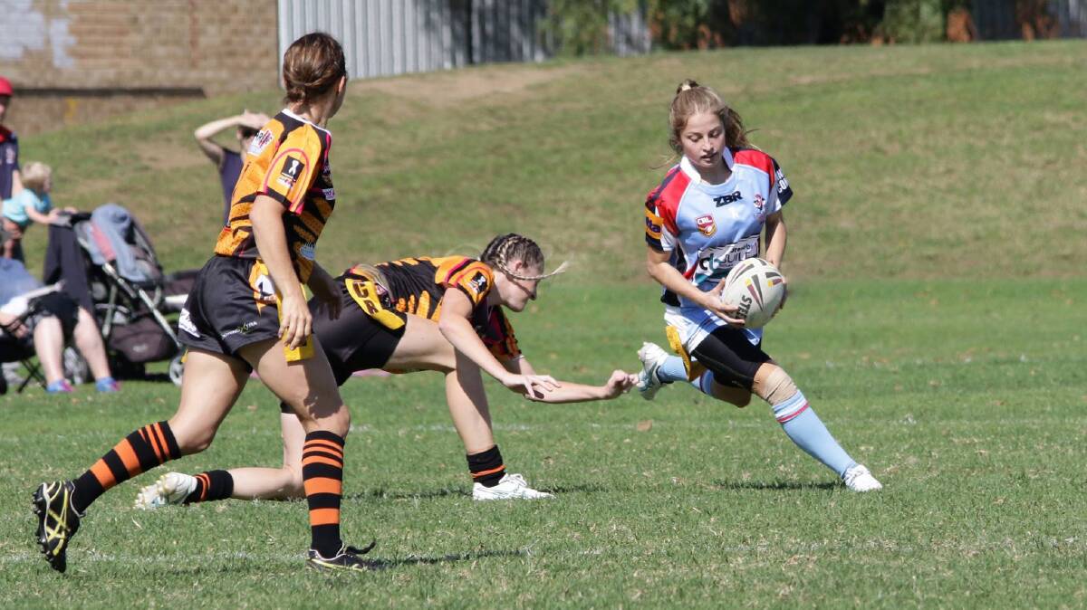 Fancy footwork: Jamerah Picker-Reeve puts on a quick step to get around a pair of Bay Tigress defenders on Sunday. Picture: Peter Sheales. .