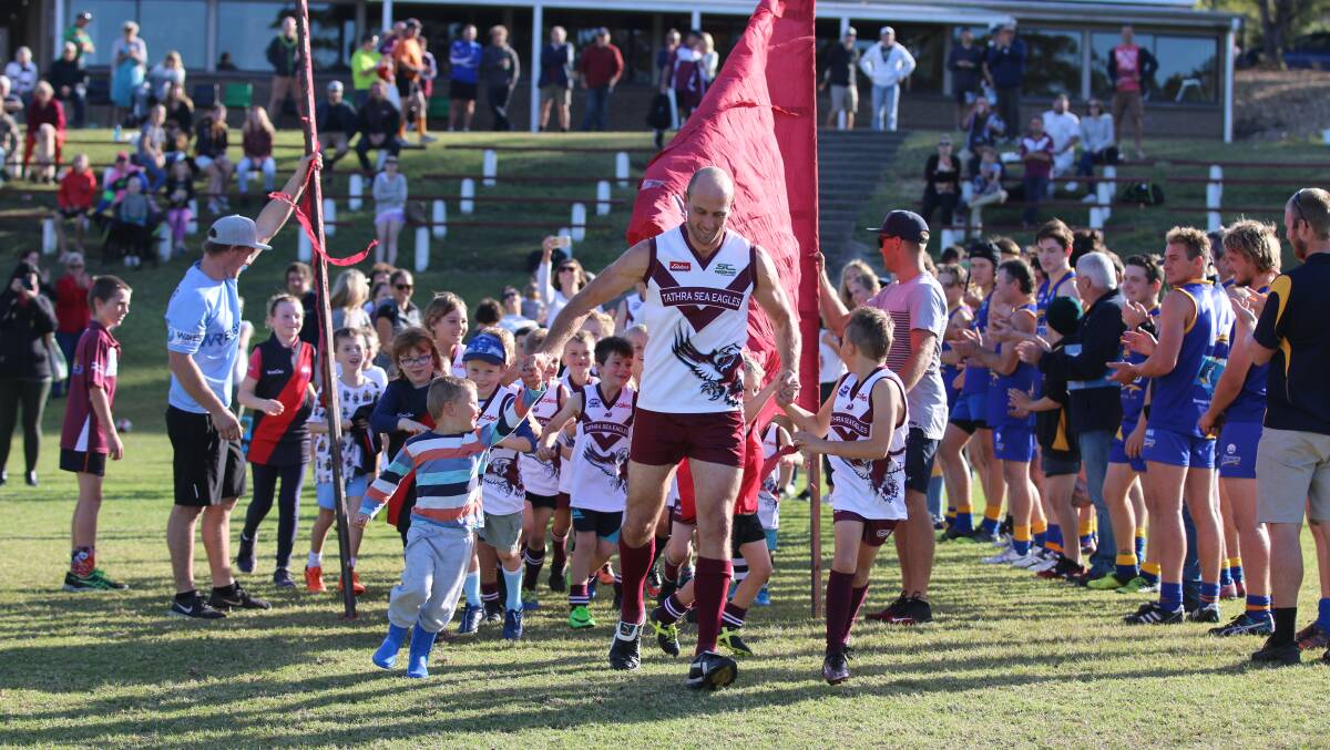 David Little and his boys break through a commemorative banner with Auskick juniors helping him run out for his 300th game on Saturday. 