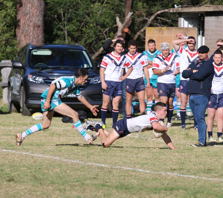 Rooster Trent Galli dives over the try-line in reserve grade with club-mates watching on. 