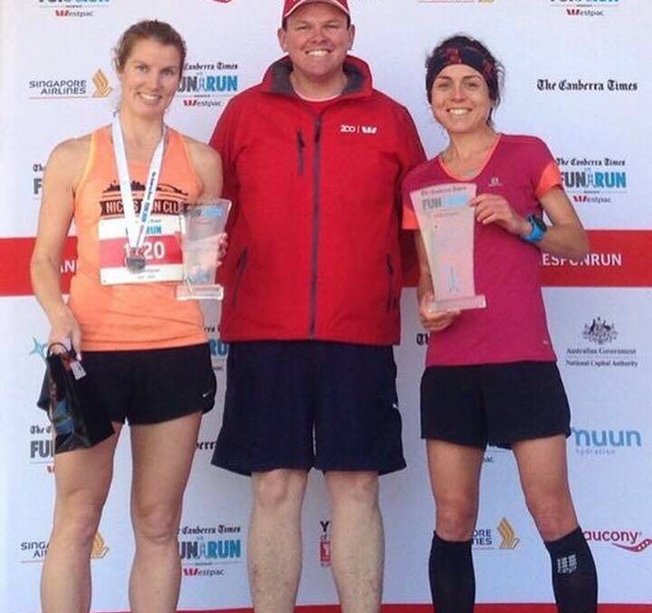 Winner: Steph Auston (right) accepts her trophy during presentations at the Canberra Times fun run 14km after setting a blistering pace to the top female entrant. 