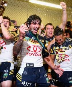 Cheers: Johnathan Thurston celebrates the premiership. Picture: Cameron Spencer