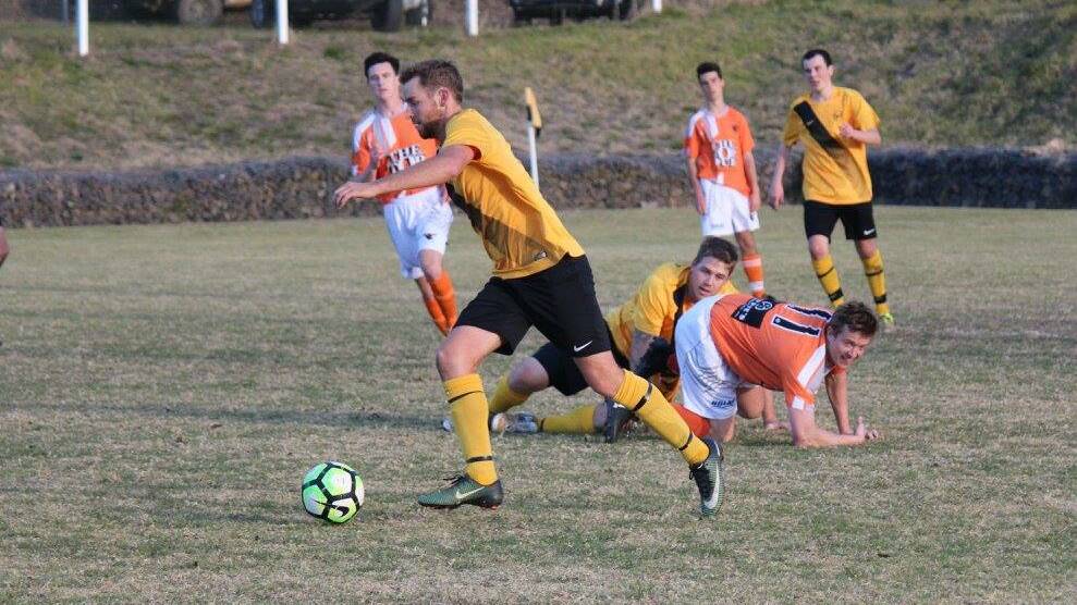 Footwork: Tiger Tom Adams emerges with the ball after a tackling contest against the Pambula Penguins on Sunday. Picture: Caitlin Johnson. 