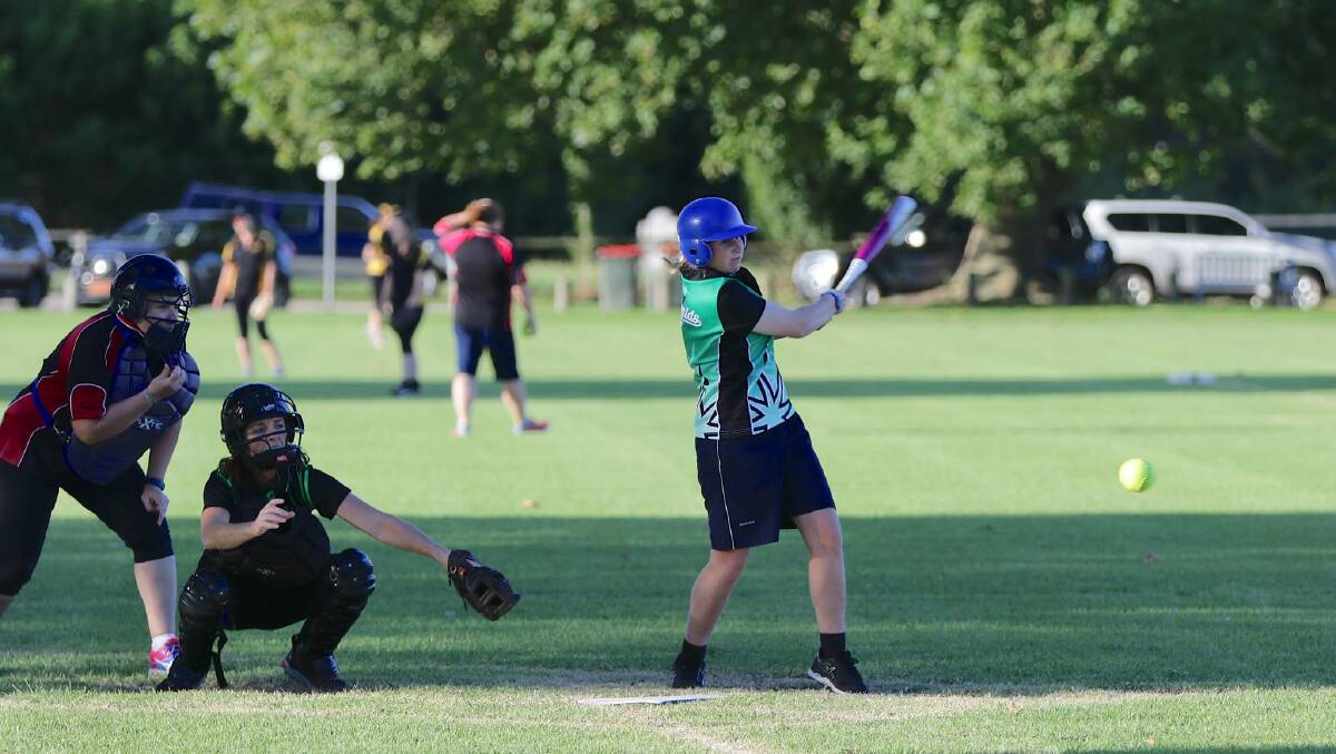 Softball: A batter launches the ball towards the outfield during a match this season with the grand finals on Saturday. Picture: Peter Sheales. 