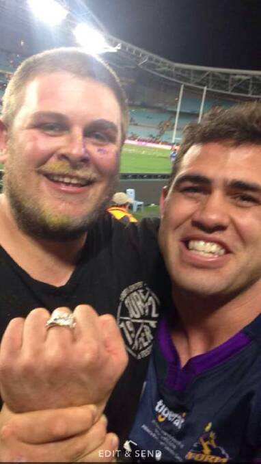 Elated: Dale Finucane catches up with good mate Billy Hudson after the game and shows off his premiership ring with the Storm winning 34-6. Picture: Facebook.