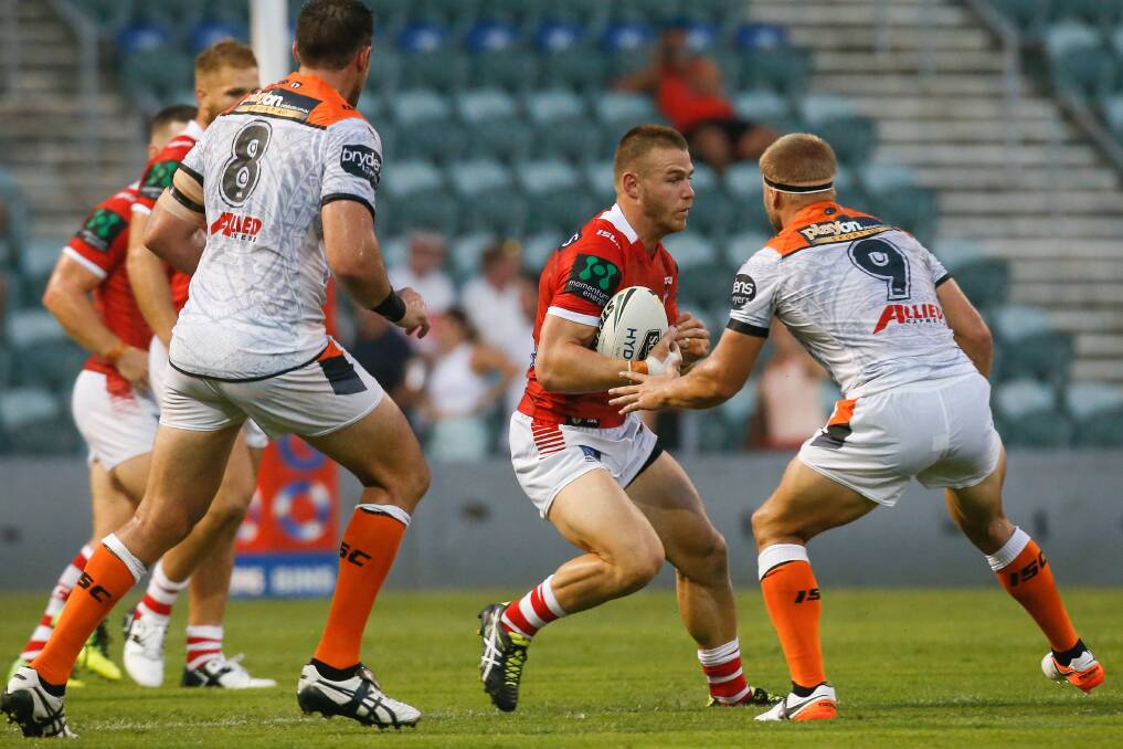 Locked in: Euan Aitken makes a run for the Dragons during a trial game against the Wests Tigers on Saturday. The young gun has signed a three-year deal. Picture: Adam McLean.