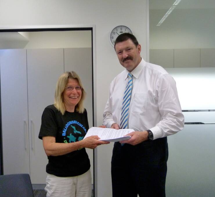 Karen Joynes of Bermagui hands 2165 signatures from the petition to ban the release of balloons to Federal Member for Eden-Monaro Mike Kelly. 