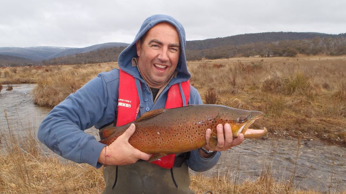 NICE BROWN: DPI Fisheries Officer Sean Lethlean with a brown trout on the Eucumbene River. 