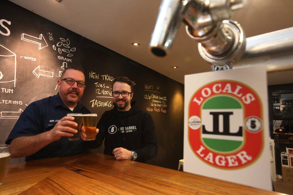 Illawarra Brewing Company's Dave McGrath and Five Barrel Brewing's Phil O'Shea try a glass of their joint creation - Locals Lager. They're aiming to get it into bars across the region. Picture: Robert Peet