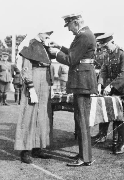Pearl Corkhill is presented with her Military Medal by the Australian Governor-General, Lord Foster. "I can't see what I have done to deserve it," she said.
