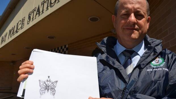 Crime manager Detective Inspector Kevin McNeil with a copy of the butterfly pendant. 