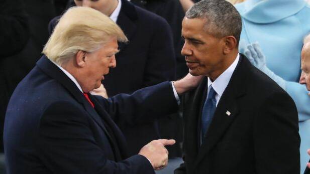 America First: Donald Trump speaks to Barack Obama after his inaugural speech, in which he condemned his predecessors. Photo: AP