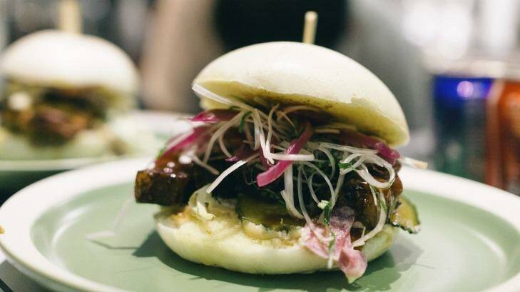 Slow-braised pork belly bao topped with leek and shiso red onion salad, sesame dressing and hoisin ketchup at Little Bao.
