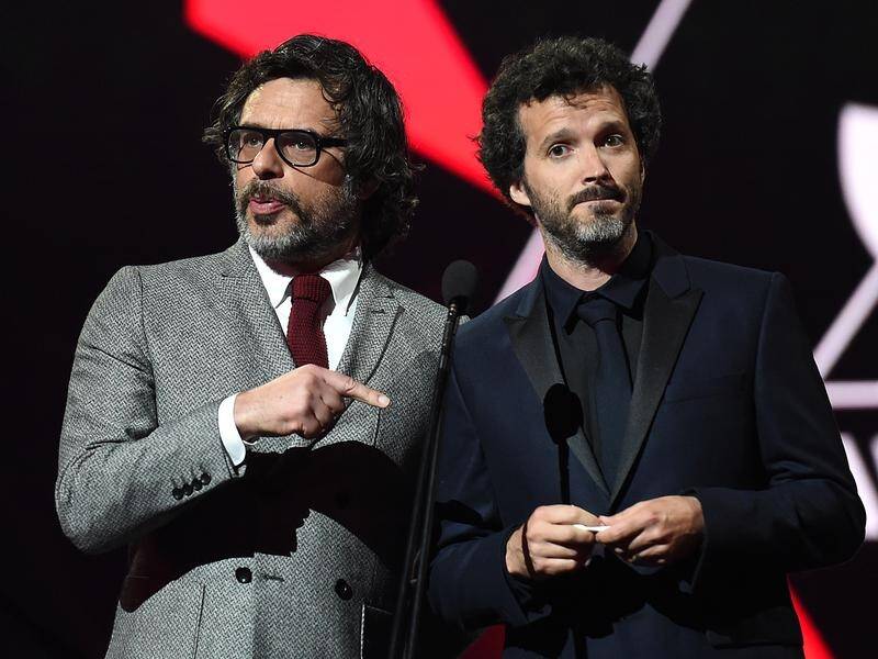 Flight of the Conchords have postponed their UK tour after Bret McKenzie (R) injured his hand.