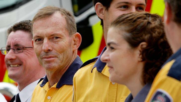 Prime Minister Tony Abbott prepares to receive a medal for 10 years of voluntary service to fire-fighting Photo: Lisa Maree Williams