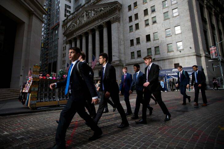 Pedestrians walk along Wall Street in front of the New York Stock Exchange (NYSE) in New York, U.S., on Monday, Oct. 23, 2017. U.S. stocks got off to a slow start?? as investors prepared for a big week of earnings reports, awaited possible changes at the Federal Reserve and monitored the progress of tax reform. Photographer: Michael Nagle/Bloomberg