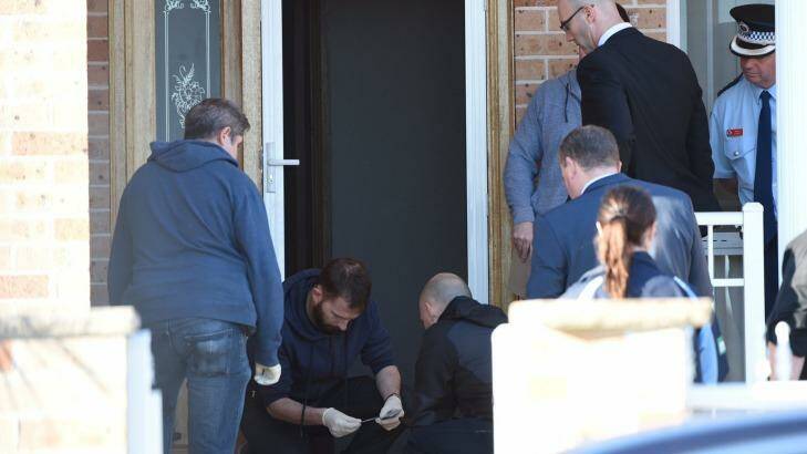 Police at the scene of one of the raids in Guildford. Photo: Nick Moir