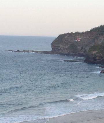 Cliff fall: a rescue helicopter arrives at Warriewood beach. 