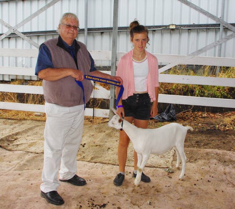 Dairy goat judge Roger Matthews presents Kelly Wheatley with the junior handler ribbon.