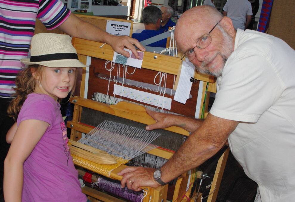 John Fuary shows Lydia Weber how to weave at the handicraft demonstrations in the Bega Showground pavilion.