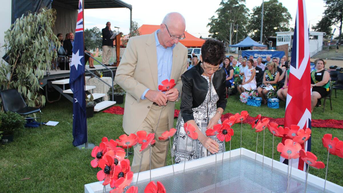 Governor of NSW General David Hurley and his wife Linda lay the last poppies in the General Salute to the Fallen at the Bega Show.