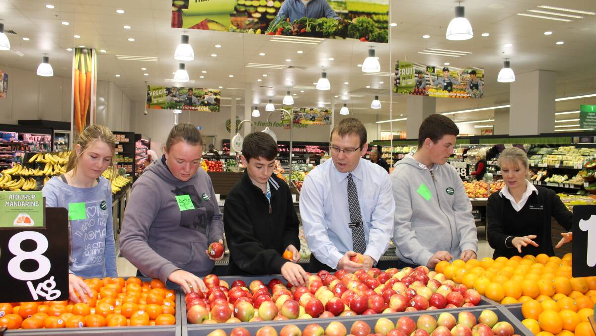 Learning about fruit and how it can be displayed from Bega Woolworths supermarket store manager Matthew Jorgenson and assistant manager Lisa Payne are students (from left) Emily Monck, Aysha Geoghegan, Aidan Coady and Nick Leslaighter at the Work Inspiration program.