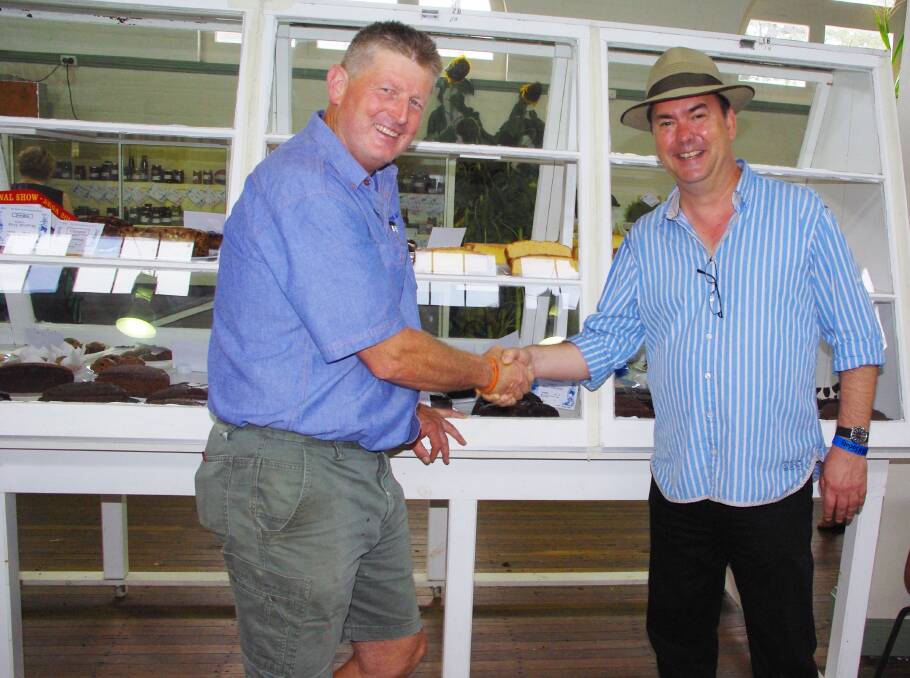 David Grainger is congratulated for winning the men’s chocolate cake by Simon Marnie, oyster judge and all-round Bega Show enthusiast.