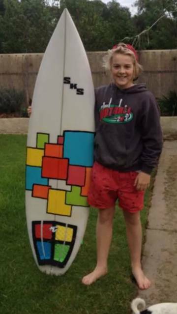 Sam with the surfboard he shaped with his father, which has been found on Brown Mountain.