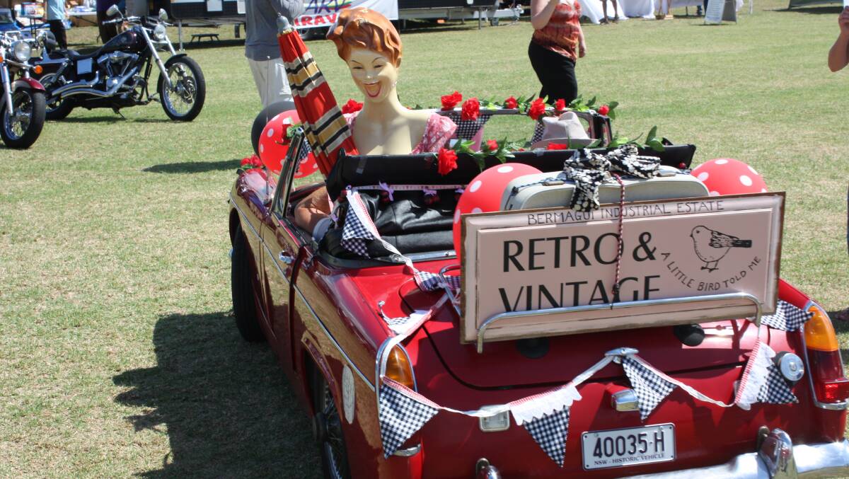Beatle Collins and Chris McKay from A Little Bird Told Me vintage collectibles drive off in their distinctive decorated vehicle.