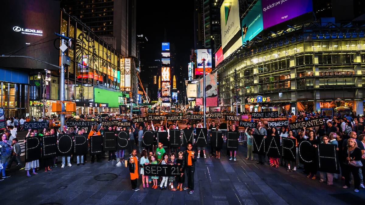 In New York on August 28, people gathered in Times Square to promote the global People’s Climate March. Photo: NYC Light Brigade. 