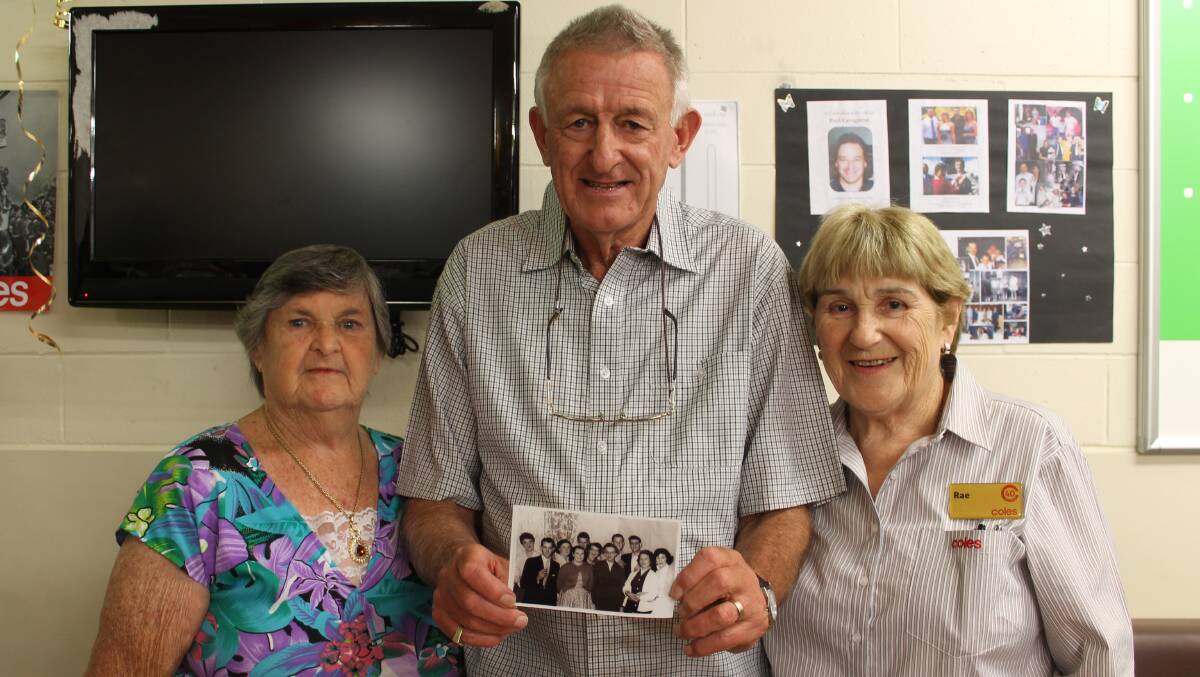 Peter Mullaney (centre) holds a photograph of himself and Coles colleagues from Bega in 1958. Also in the photograph are Joan Rootsey (left), now retired, and Rae Teer, who still works for Coles. 