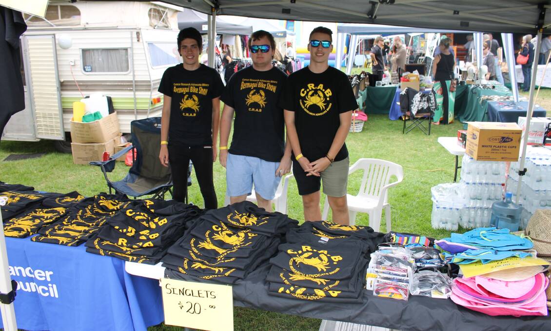 Store volunteers Zac Aitkenshead (left), Chris Crane and Tyler Crane from Canberra help by selling shirts.